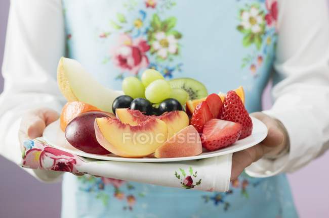 Mulher que serve prato de frutas frescas — Fotografia de Stock