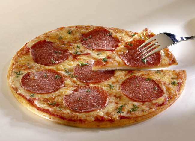 Pizza de salami con hierbas - foto de stock