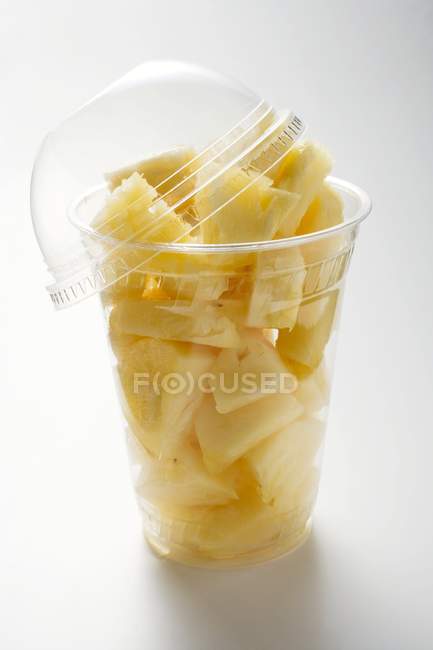 Pineapple chunks in plastic beaker — Stock Photo