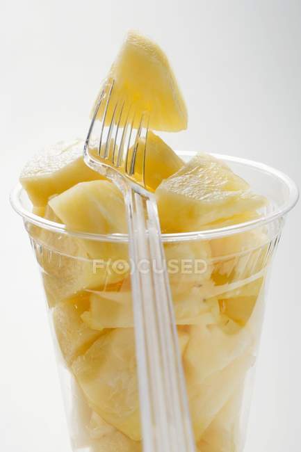 Pineapple chunks in plastic beaker — Stock Photo