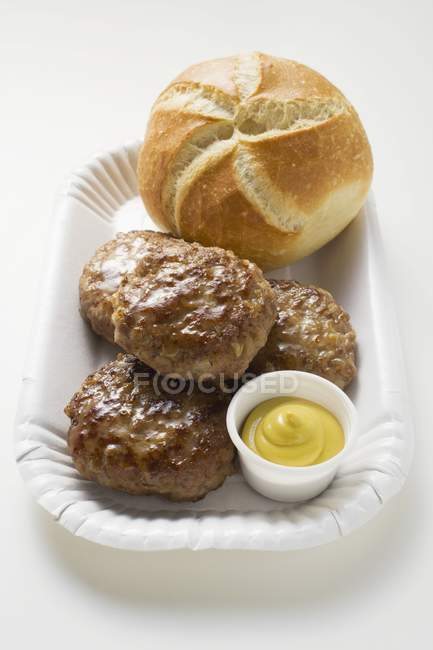 Beef burgers with mustard and bread roll — Stock Photo
