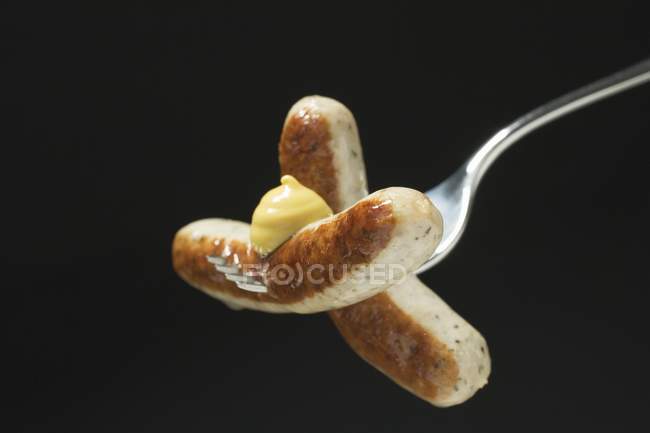Enchidos com mostarda em garfo de madeira — Fotografia de Stock