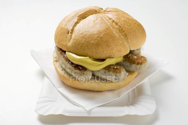 Sausages and mustard in bread roll — Stock Photo