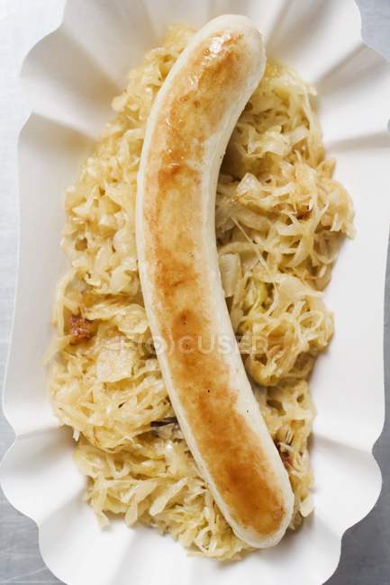 Salsiccia con crauti su piatto di carta — Foto stock
