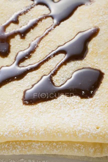 Vue rapprochée de la crêpe avec sauce au chocolat et sucre glace — Photo de stock