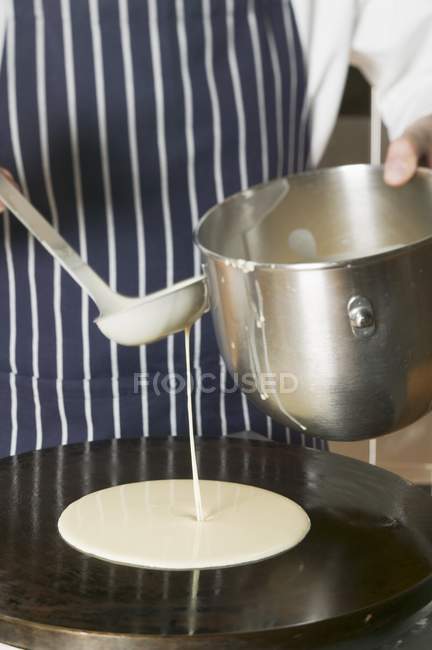 Pouring pancake mixture — Stock Photo