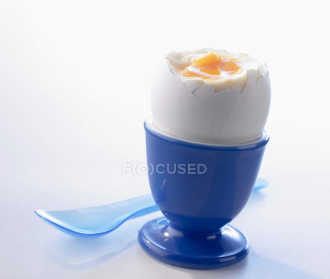 Boiled egg in blue egg-cup — Stock Photo