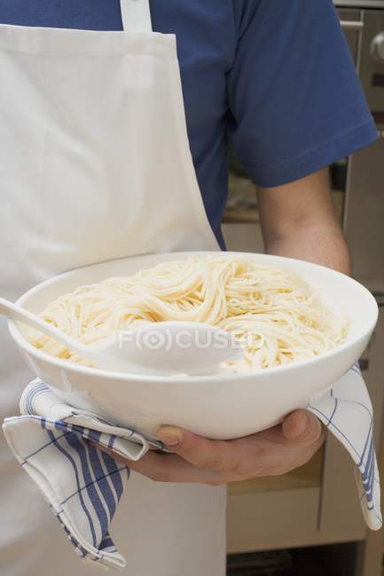 Чоловік тримає чашу приготованих спагеті — стокове фото