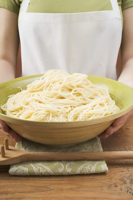 Femme tenant bol de spaghettis cuits — Photo de stock