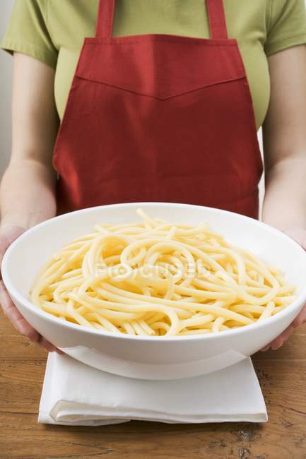 Femme tenant bol de macaroni — Photo de stock