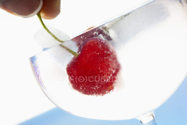 Fresh cherry in a glass of ice water — Stock Photo