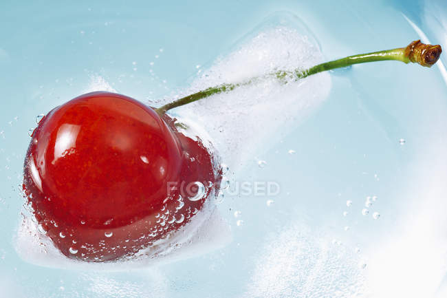 Cereja fresca flutuando em água gelada — Fotografia de Stock