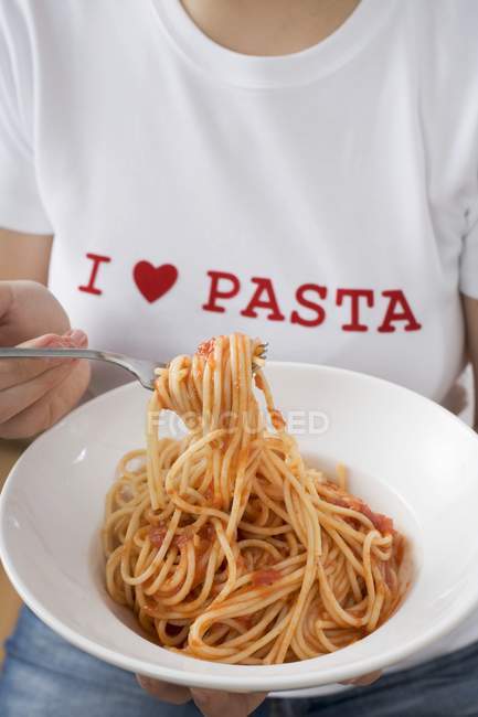 Mulher comendo espaguete com molho de tomate — Fotografia de Stock