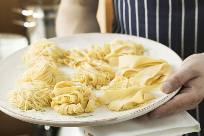 Person holding different types of pasta — Stock Photo