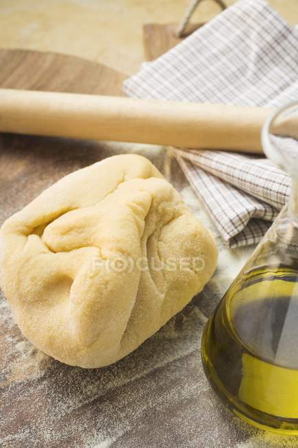 Pasta dough and rolling pin — Stock Photo