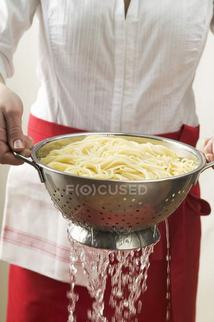 Espaguetis cocidos drenantes - foto de stock