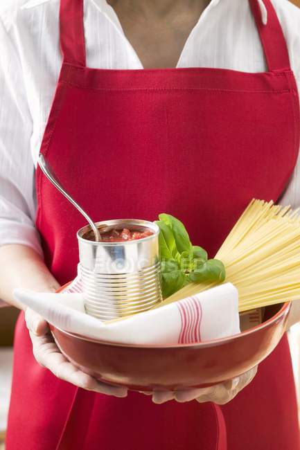 Mulher segurando lata de tomate e espaguete — Fotografia de Stock