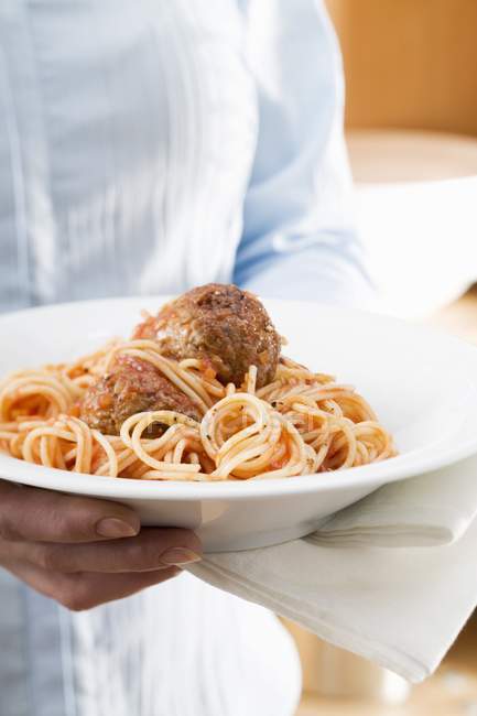 Woman holding plate of spaghetti — Stock Photo