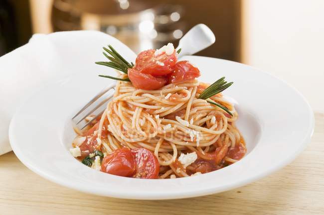 Pasta de espagueti con tomates y romero - foto de stock