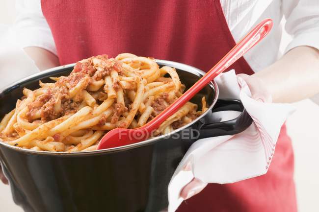 Woman serving macaroni pasta with mince — Stock Photo
