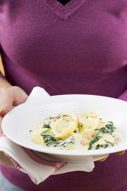 Femme avec assiette de pâtes tortellini — Photo de stock