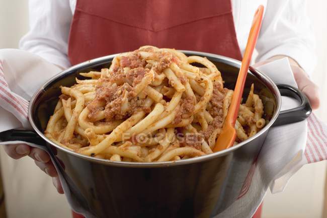 Woman serving macaroni pasta with mince — Stock Photo