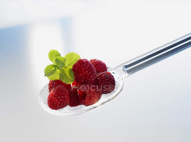 Raspberries on plastic spoon — Stock Photo