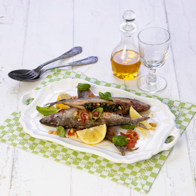 Sardinen gefüllt mit Spinat und Pinienkernen auf weißem Teller über Handtuch — Stockfoto