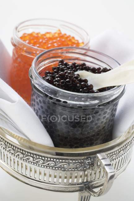 Black and red caviar in jars — Stock Photo