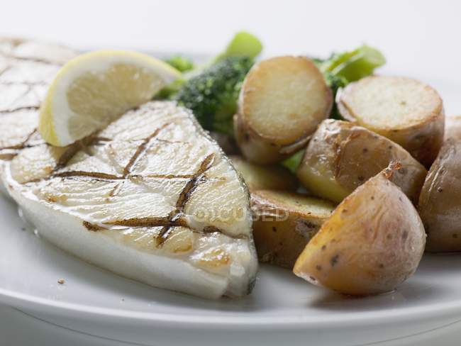 Cod steak with baked potatoes — Stock Photo