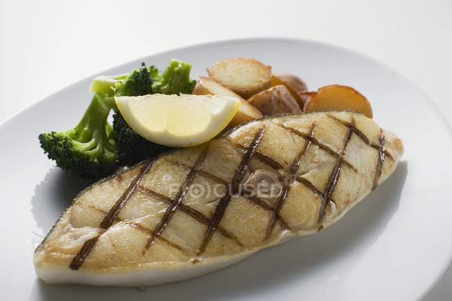 Filete de bacalao con patatas al horno - foto de stock