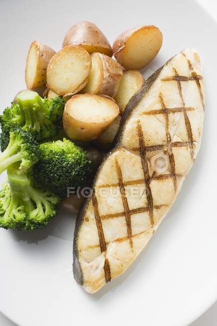 Cod steak with baked potatoes — Stock Photo