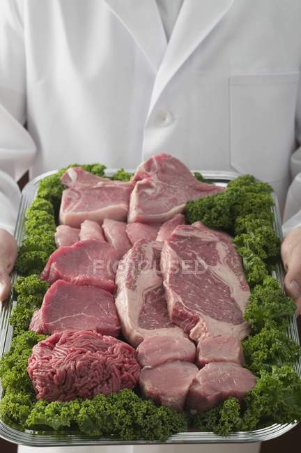 Butcher holding tray — Stock Photo