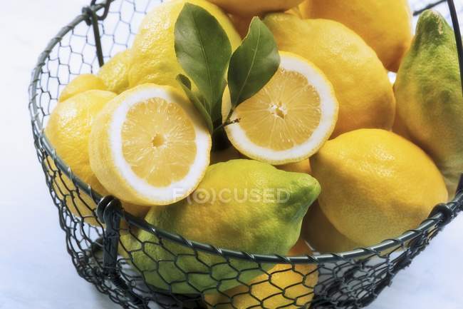 Organic lemons in wire basket — Stock Photo
