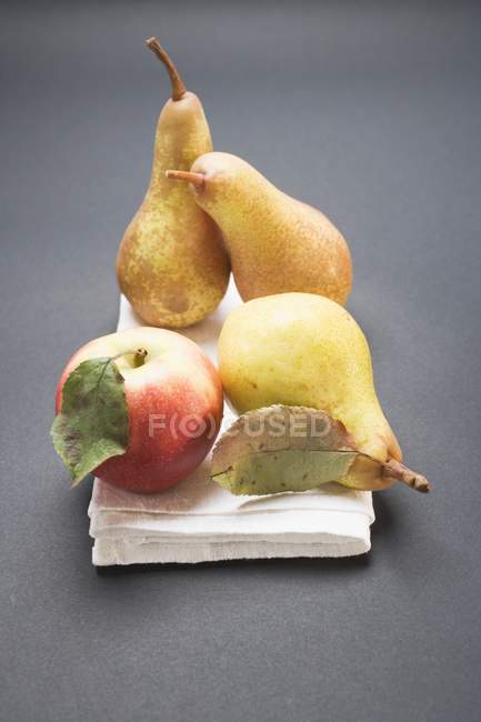 Три груши и яблоко — стоковое фото