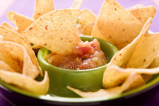 Vista close-up de chip Tortilla mergulhado em tomate Salsa — Fotografia de Stock