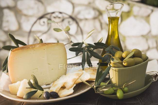 Olives with cheese, crackers and olive oil — Stock Photo