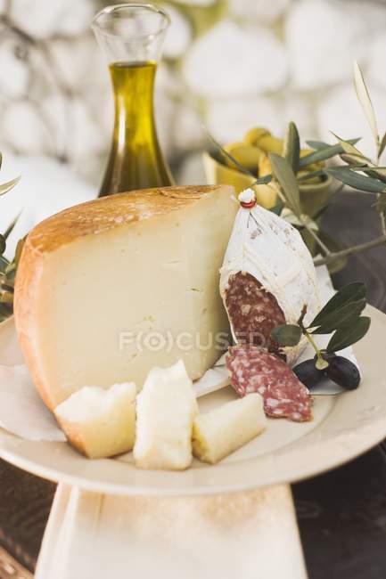 Fromage avec salami et olives sur la table — Photo de stock