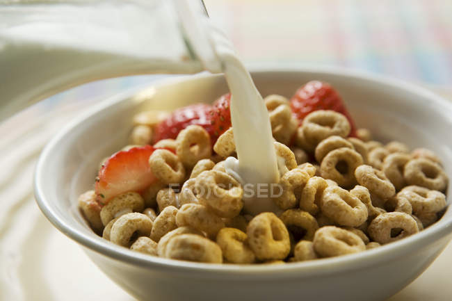 Pouring milk over cereal — Stock Photo