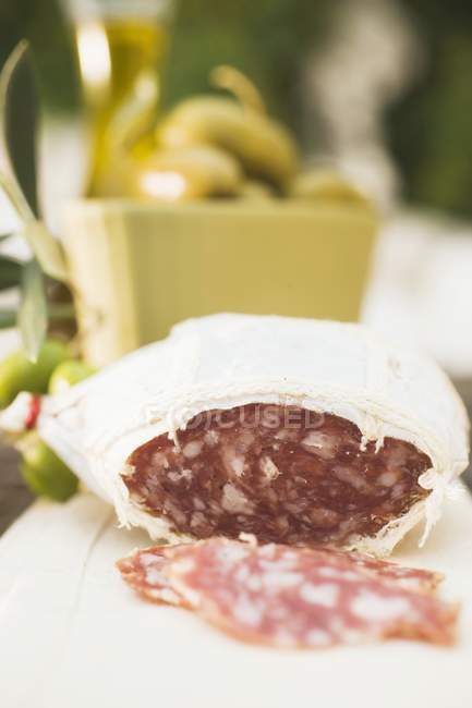 Сыр с салями и оливками на столе — стоковое фото