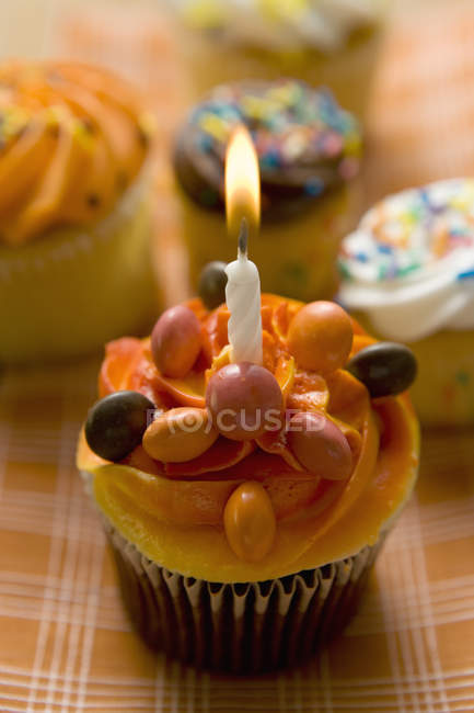 Pasteles pequeños con una vela de cumpleaños - foto de stock