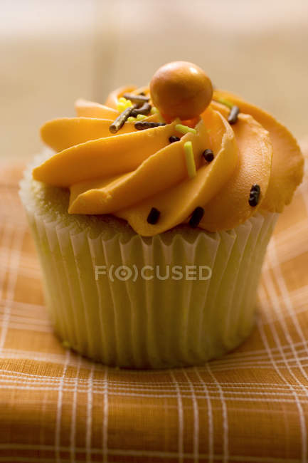 Muffin with orange cream topping — Stock Photo