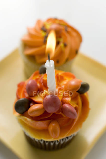 Assorted muffins, one with birthday candle — Stock Photo