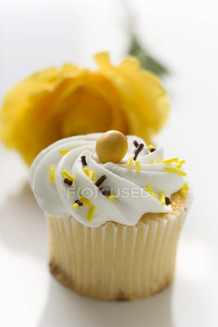 Muffin in front of rose — Stock Photo