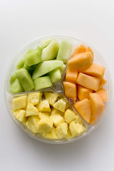 Pedaços de fruta fresca em tigela de plástico — Fotografia de Stock
