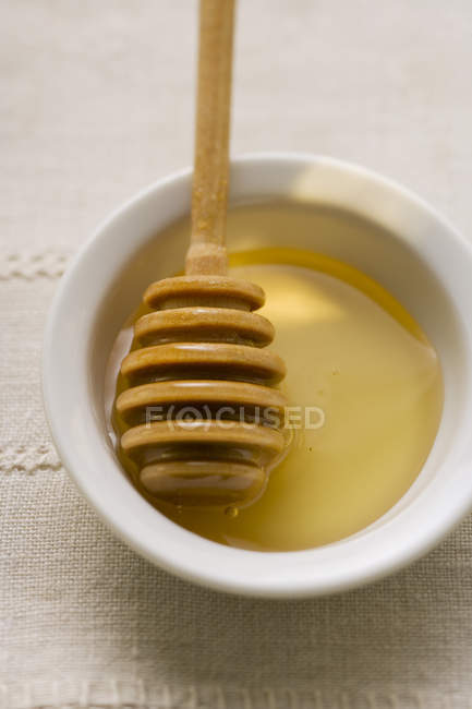 Honey dipper in bowl — Stock Photo