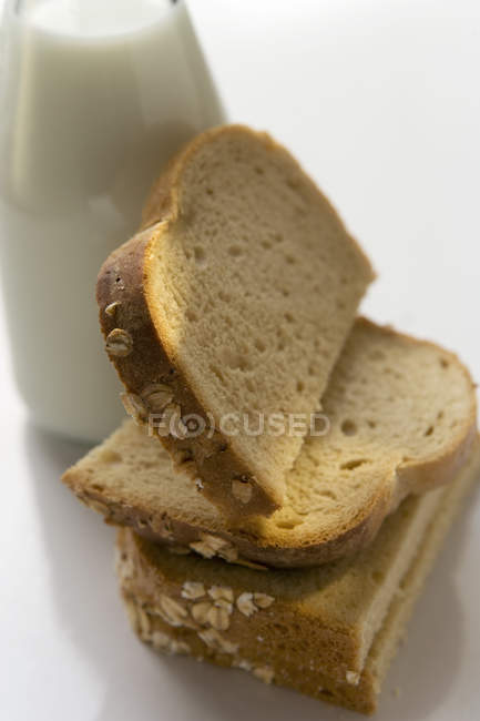 Кусочки хлеба с молочной бутылкой — стоковое фото