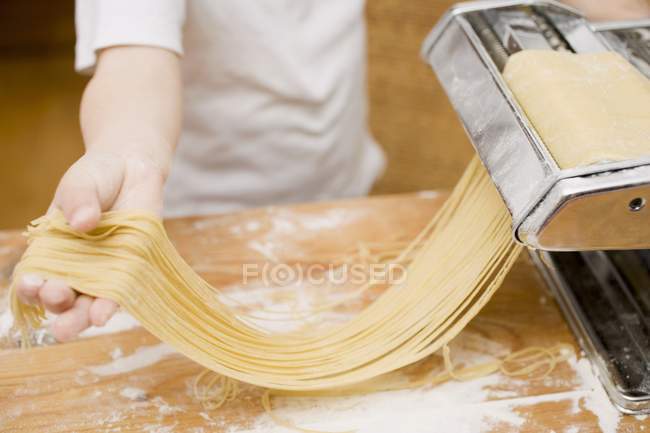 Kind macht hausgemachte Linguine Pasta — Stockfoto