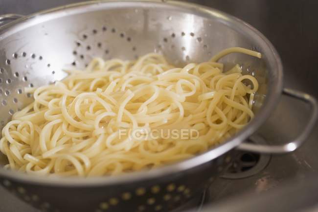 Ribbon pasta in colander — Stock Photo