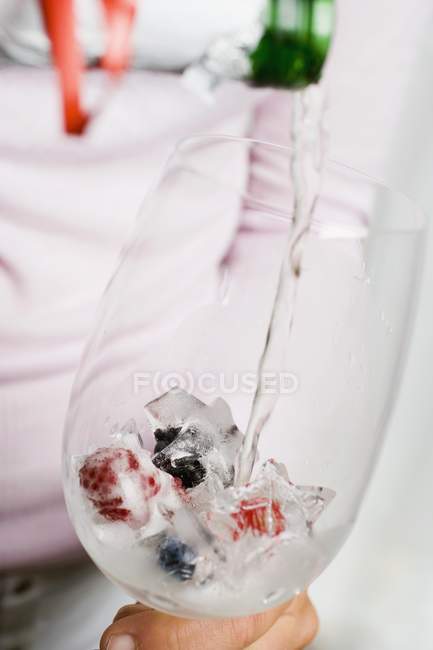 Pouring champagne onto berry ice — Stock Photo